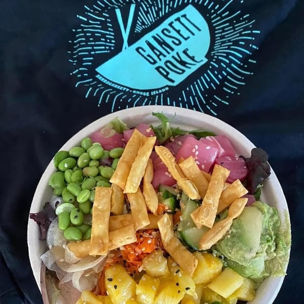 Gansett Poke bowl with tuna, edamame, pineapple, avocado, and crispy wontons on a branded shirt.